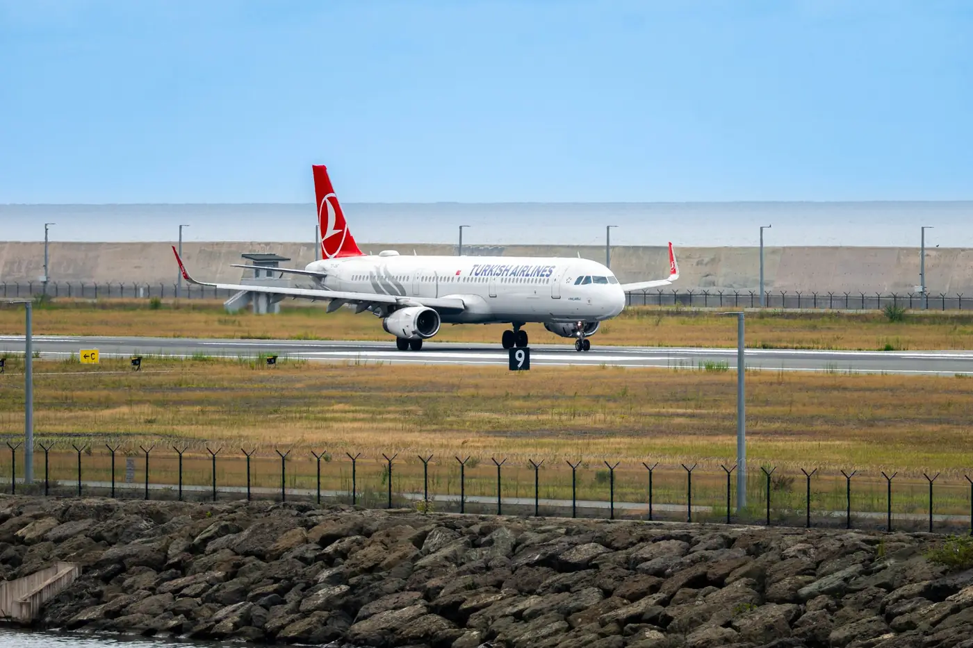 Vliegtuig van Turkish Airlines op de landingsbaan met zee op de achtergrond