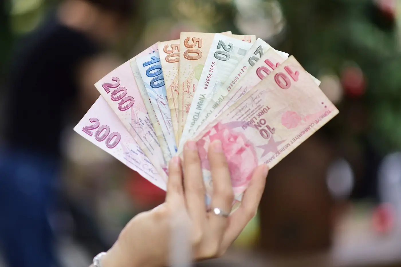 Hand met verschillende coupures Turkse lira-bankbiljetten