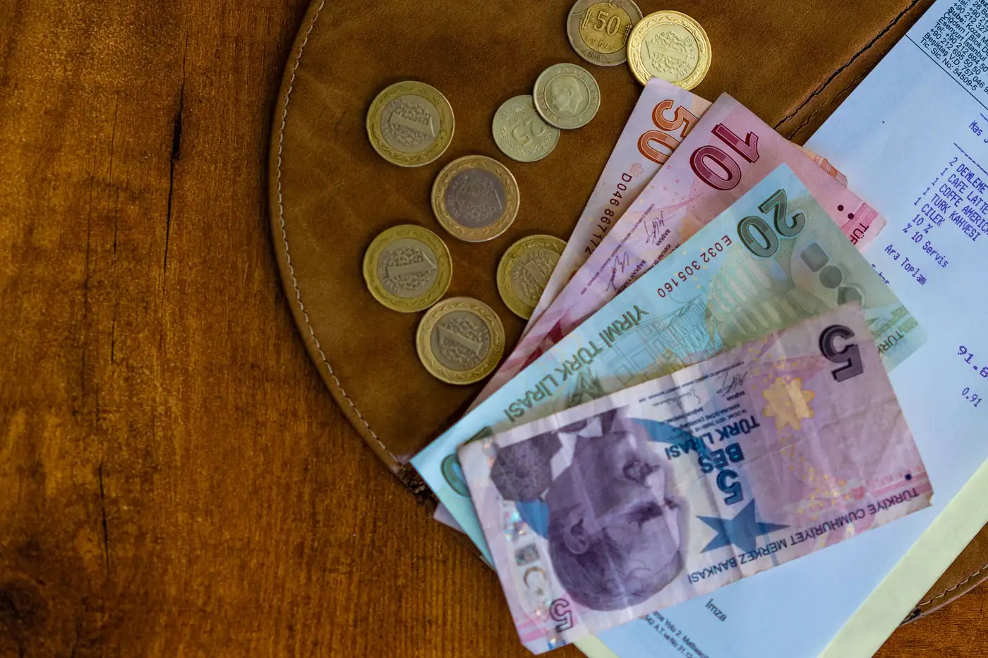 Turkse lirabankbiljetten en munten naast een kassabon