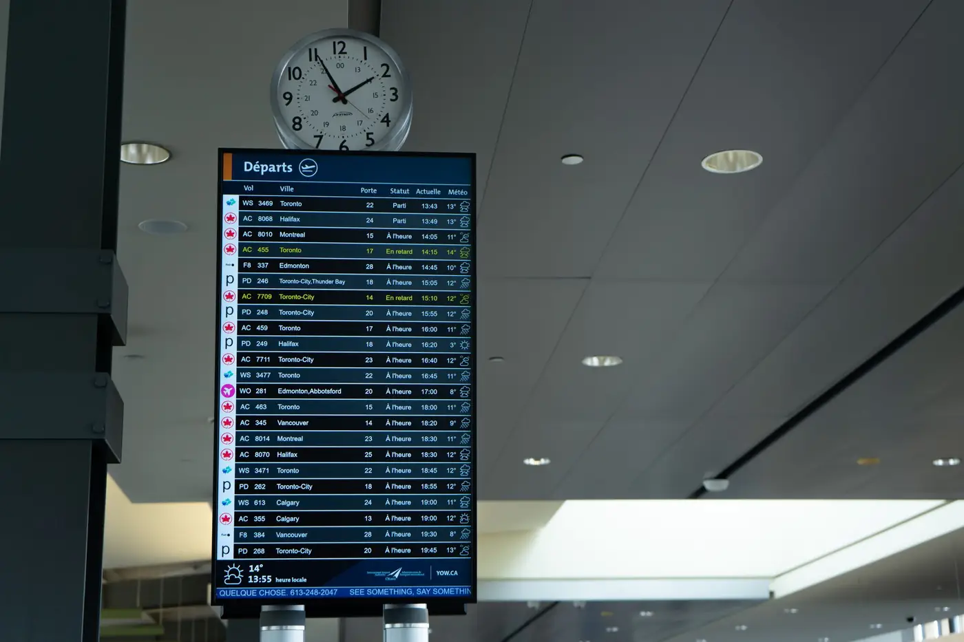 Vertrekbord met vluchttijden op een luchthaven, met een klok erboven