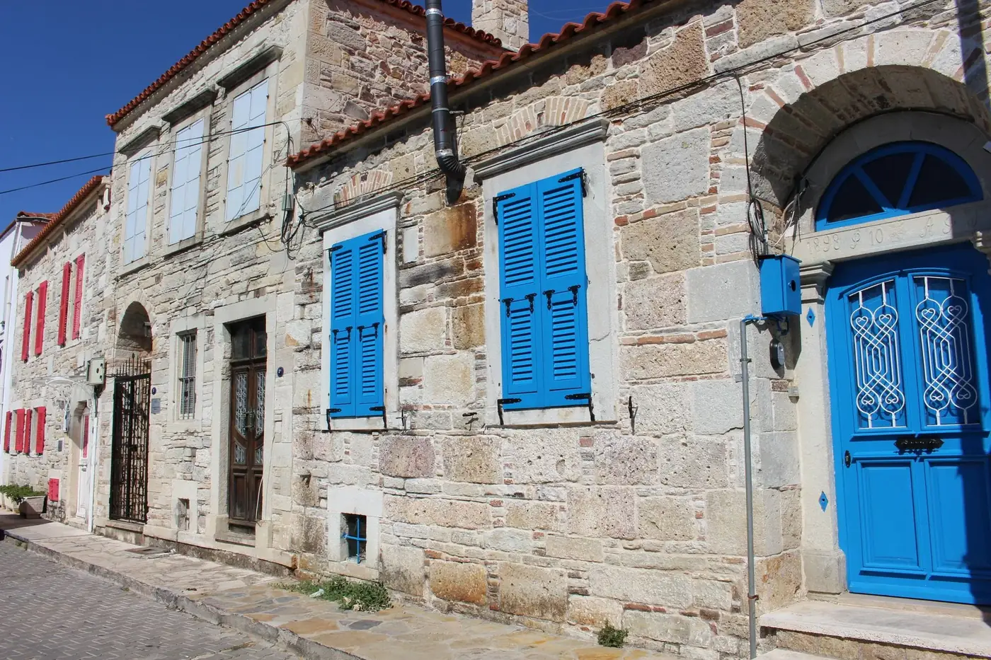 Charming Mediterranean stone houses with vibrant blue shutters and doors.