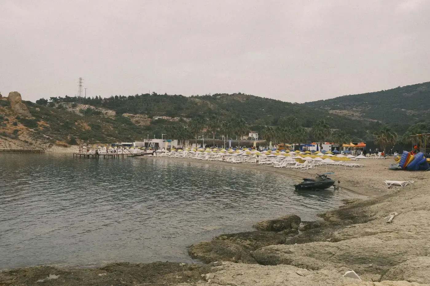 A serene beach with chairs and rocky coastline in Izmir, Turkey.