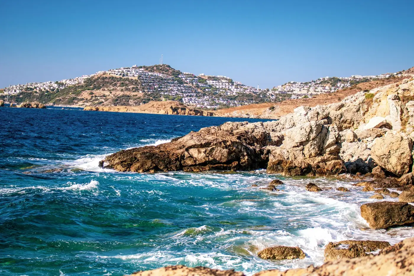 Capture of the stunning Bodrum coastline with clear blue skies and vibrant ocean waves.