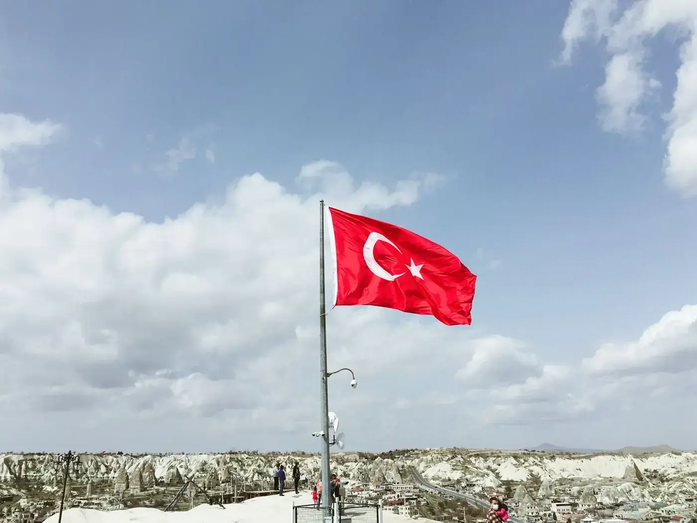 Stunning view of the Turkish flag soaring high over the unique Cappadocia rock formations.
