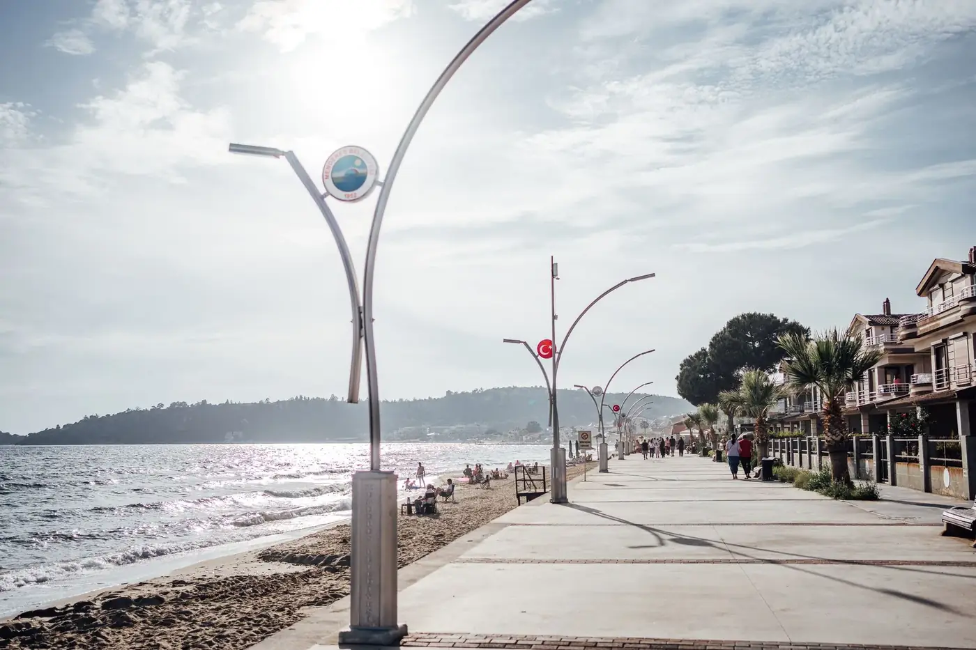 Explore the scenic boardwalk along the Özdere beach on a sunny day, perfect for a seaside stroll.