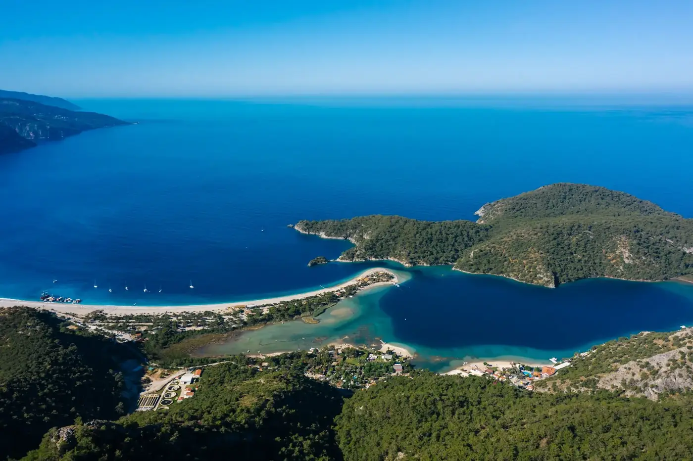 Stunning aerial view of a turquoise bay surrounded by lush greenery and a pristine coastline.