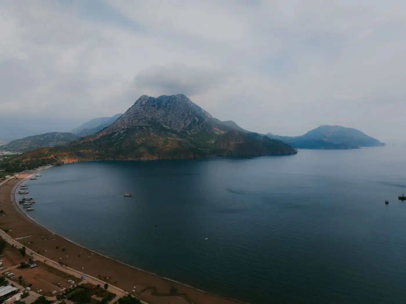 Stunning aerial shot of Olympos Beach and Tahtali Mountain, showcasing the serene coastline and lush mountain landscape.