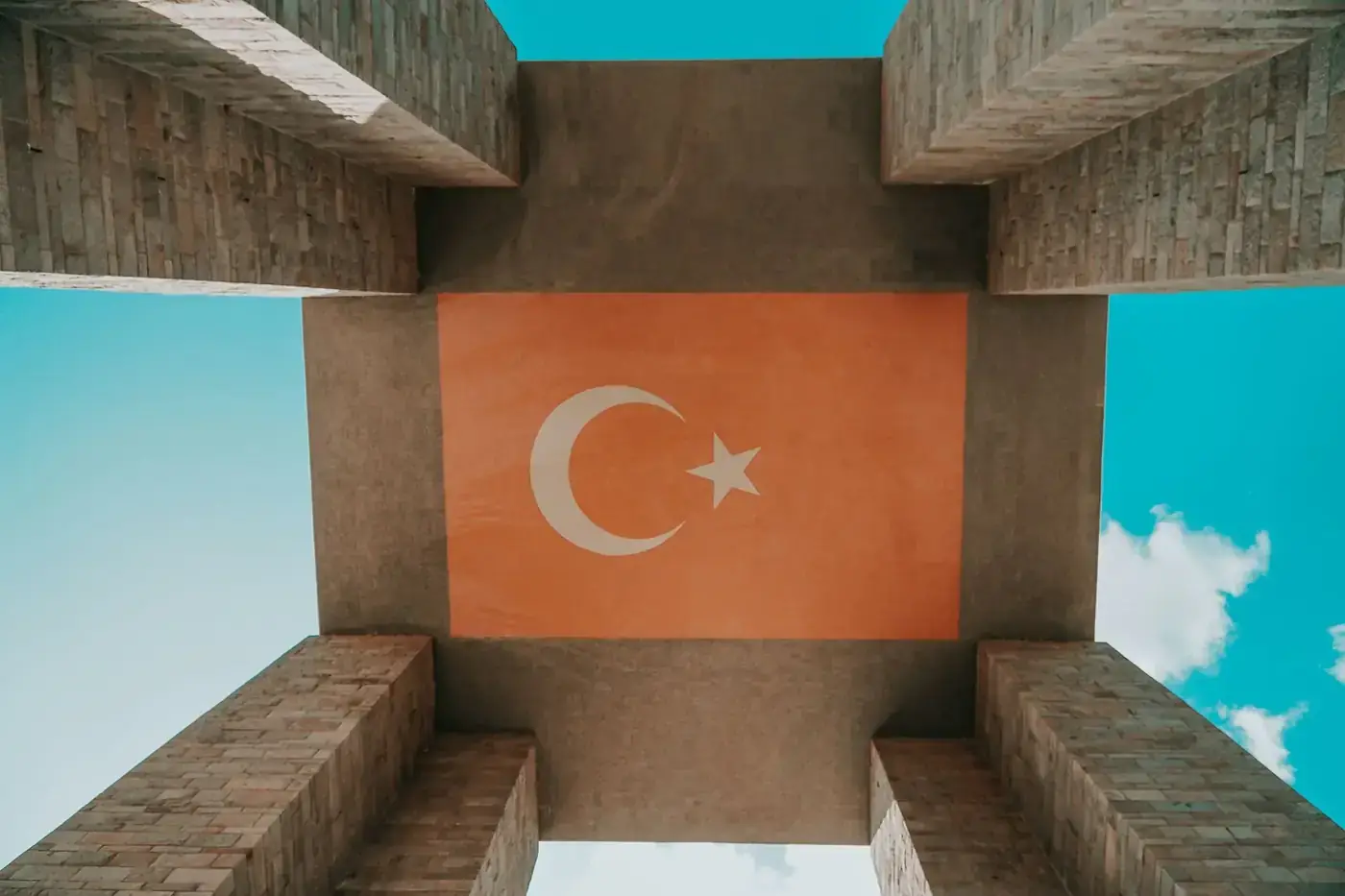 A striking view from below of the Çanakkale Martyrs' Memorial in Turkey displaying the Turkish flag.