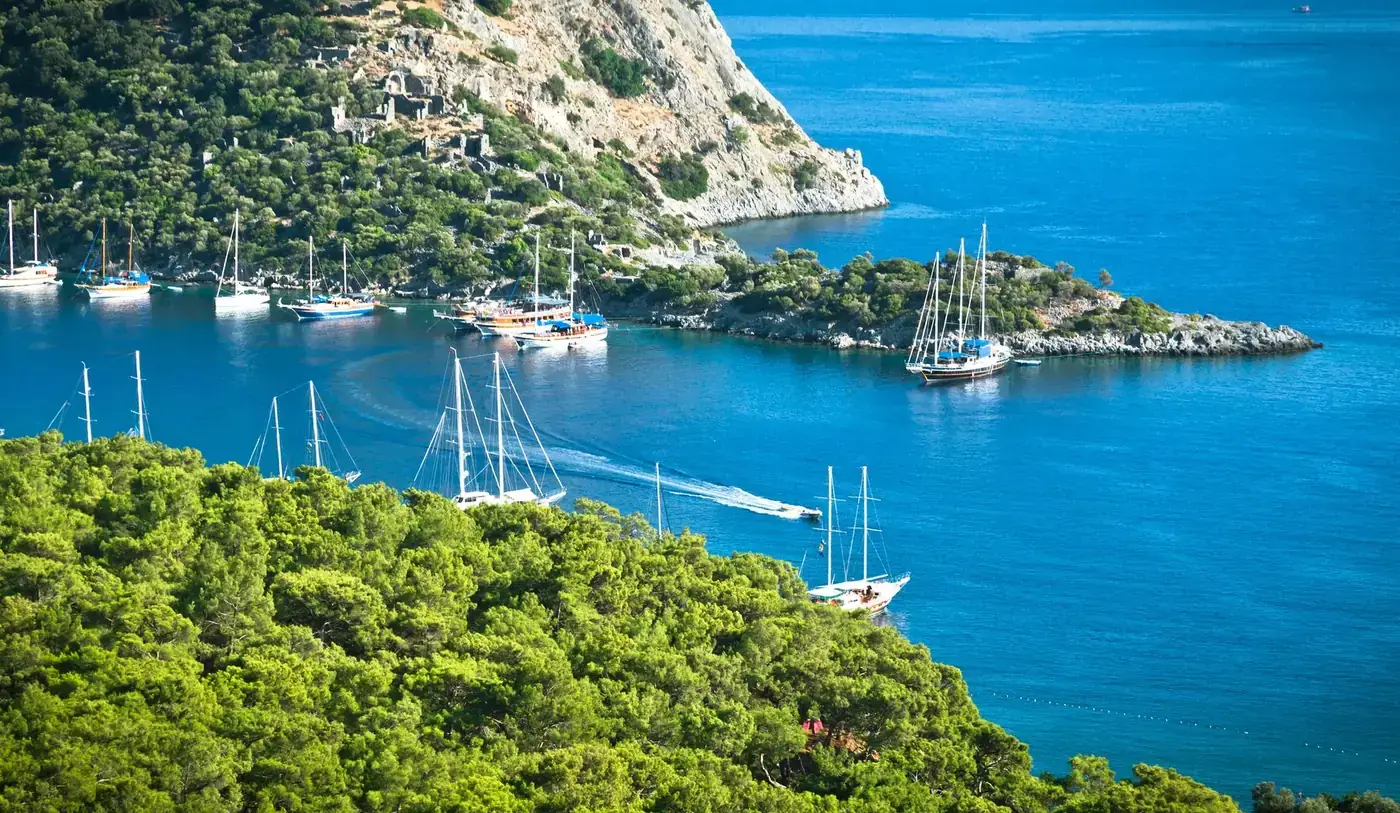 Breathtaking view of sailing yachts along Turkey's turquoise coast, perfect for summer travel.