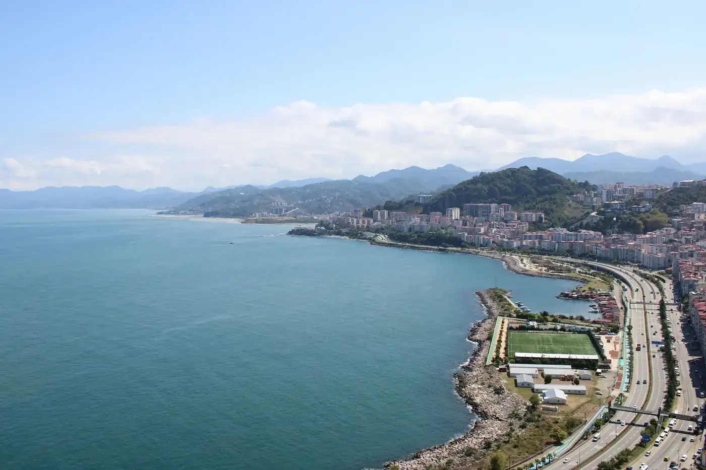 Aerial view of a coastal city with mountains and expansive sea.